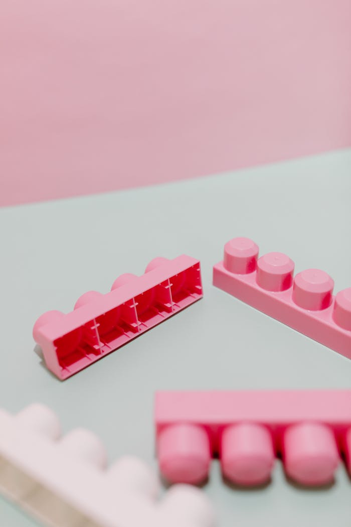 Pink and white toy building blocks on a pastel backdrop, showcasing creativity and play.